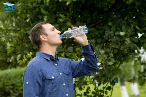 người đàn ông uống nước đóng chai