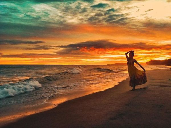 cô gái múa trên bãi biển lúc hoàng hôn
