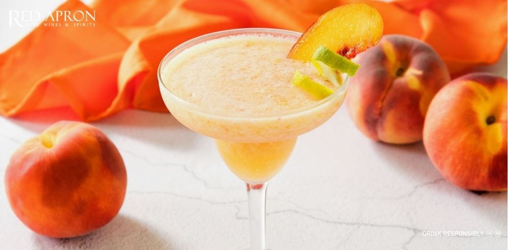 Ảnh ly Peach Margarita vị đào, màu đỏ hồng, trang trí bằng lát lime.