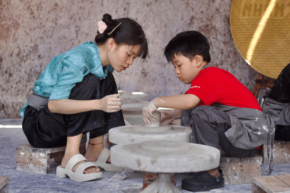 Các thành viên trong gia đình tham gia làm đồ gốm sứ vào ngày Gia Đình Việt Nam