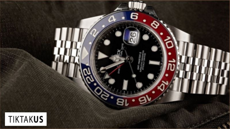 Cận cảnh mặt đồng hồ GMT, chỉ rõ kim GMT màu đỏ và vòng bezel khắc số 24 giờ]