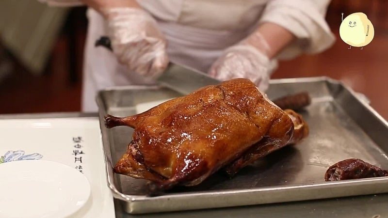 Đầu bếp đang chặt thịt vịt quay Bắc Kinh