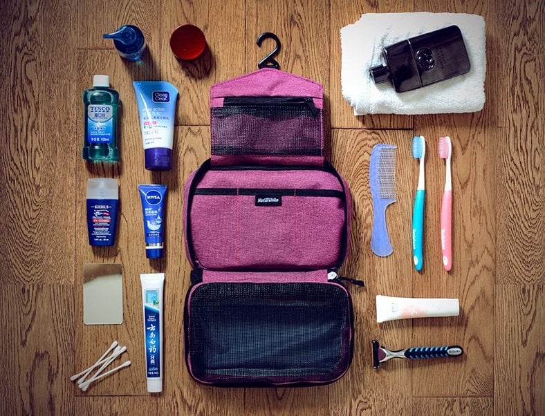 Túi đựng đồ cá nhân Naturehike XSB01 màu hồng khi mở và nhiều mỹ phẩm đồ cá nhân xếp xung quanh