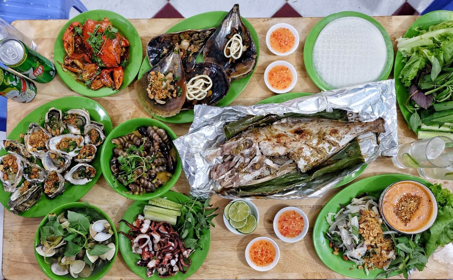 Một bàn hải sản hấp dẫn với cua sốt, cá nướng, ngao hấp, hàu nướng, bạch tuộc, sò, gỏi sứa