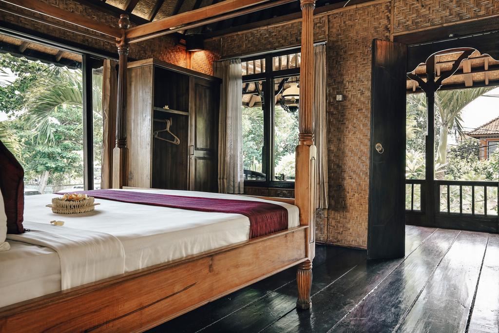 Không gian phòng nhà nghỉ Ubud View Bungalow được làm bằng gỗ, một chiếc giường có đệm trắng