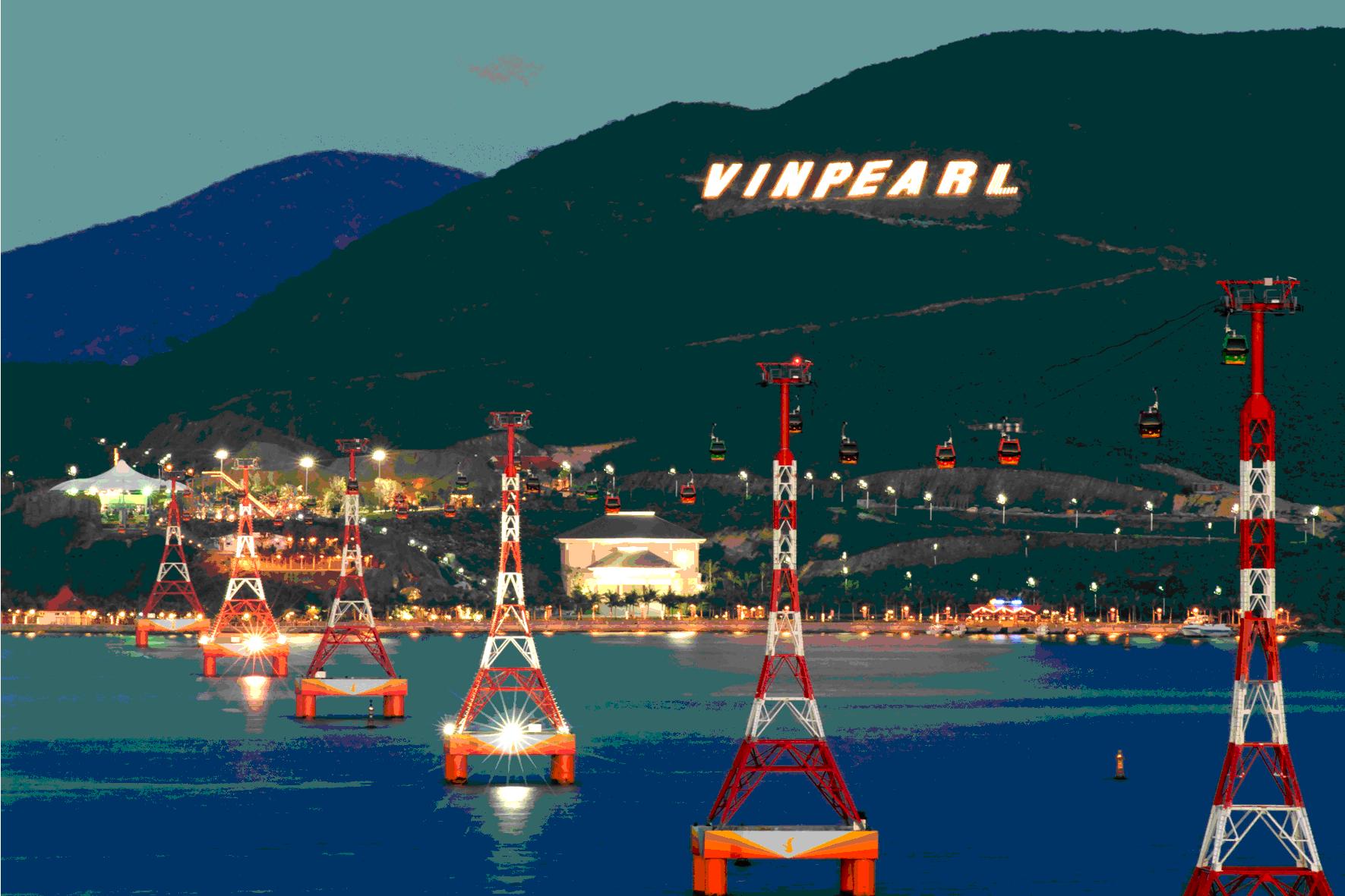 Những cột cáp treo giữa biển, phía xa là quả núi có chữ Vinpearl Land sáng đèn