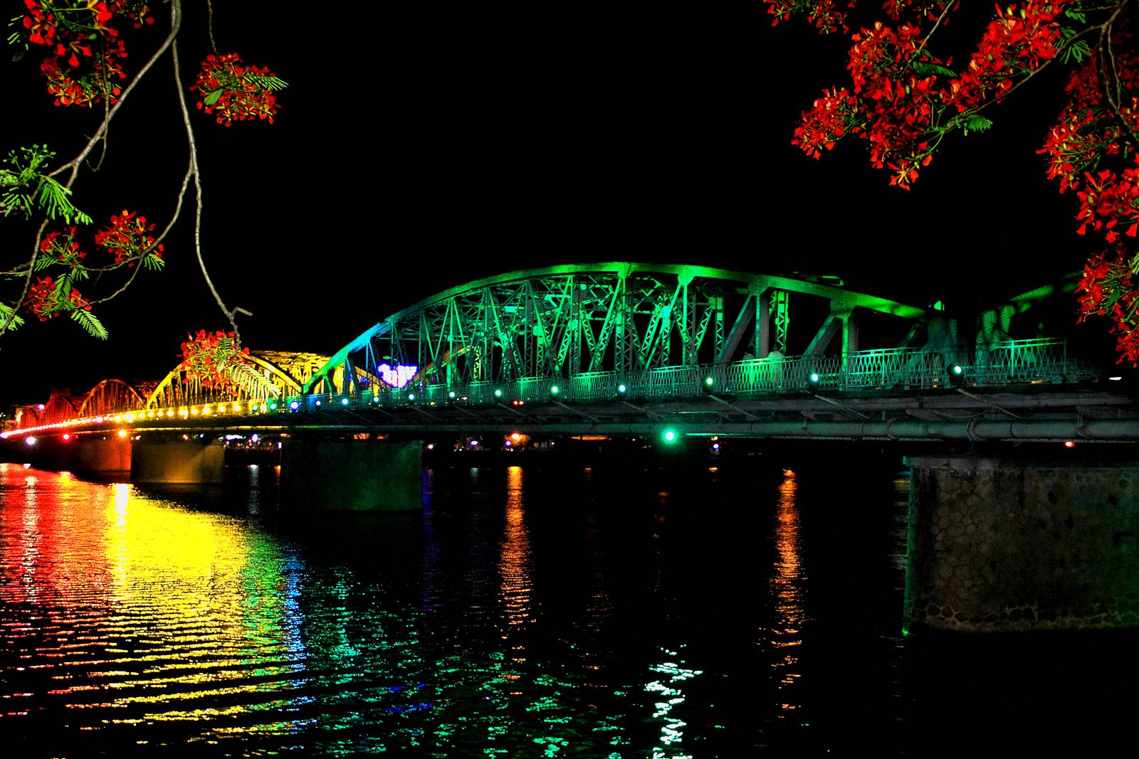 Cầu Tràng Tiền lung linh ánh đèn nhiều màu sắc in bóng xuống dòng sông Hương vào ban đêm