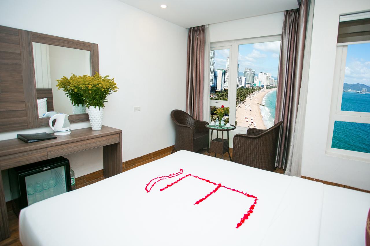 Phòng khách sạn Euro Star Hotel có chiếc giường chăn dệm trắng, bàn trang điểm và cửa sổ hướng nhìn ra biển