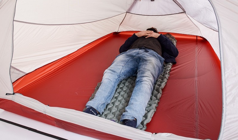 Người đàn ông nằm ngủ thoải mái bên trong không gian lều rộng rãi