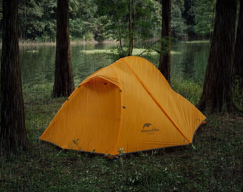 Lều màu cam được dựng trong rừng cây dưới mưa