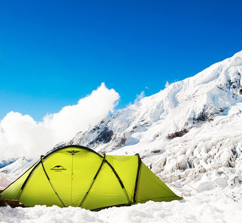 Lều cắm trại màu vàng được dựng trên địa hình băng tuyết phủ trắng xoá