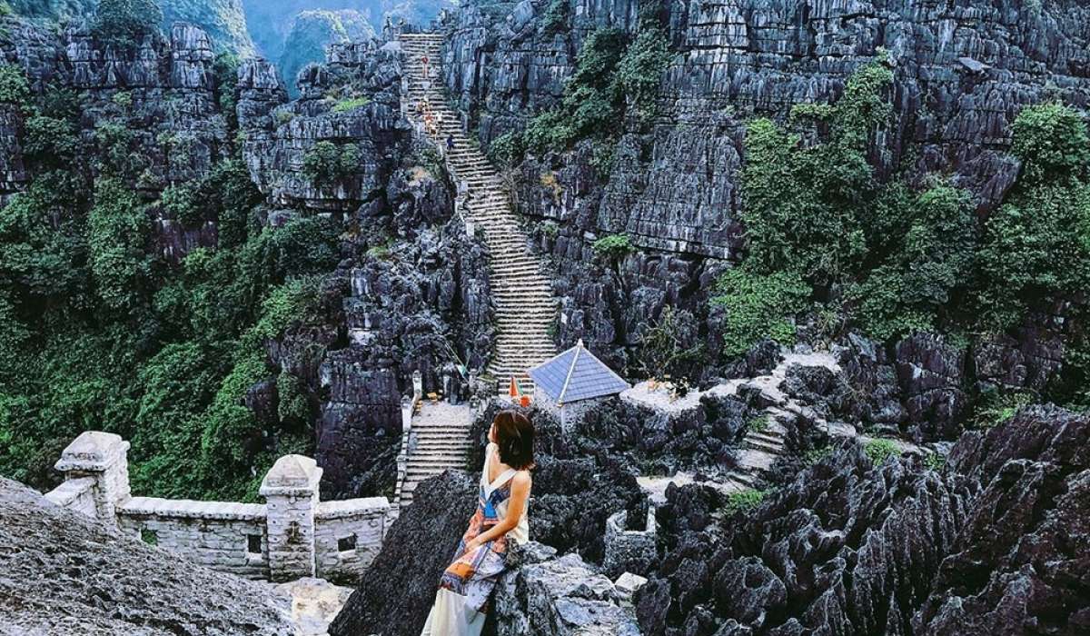 Bạn nữ checkin tại khu du lịch Ninh Bình, nhìn xuống là ocn đường bậc thang dài vô tận giữa những dãy núi trùng điệp