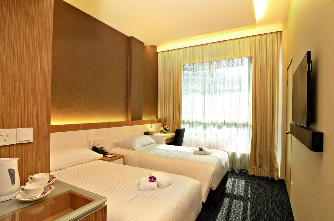 Phòng khách sạn The Seacare Hotel có 2 chiếc giường chăn đệm trắng, 1 ti vi treo tường và cửa sổ