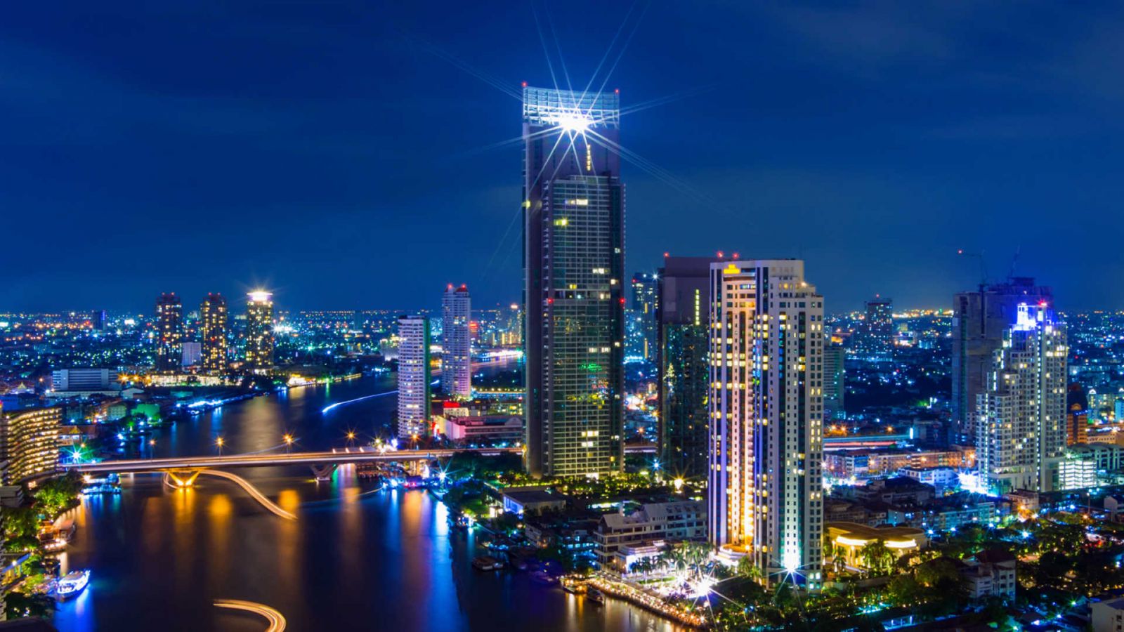 Bangkok với những toà nhà cao tầng nhộn nhịp lung linh dưới ánh đèn đêm bên cạnh con sông