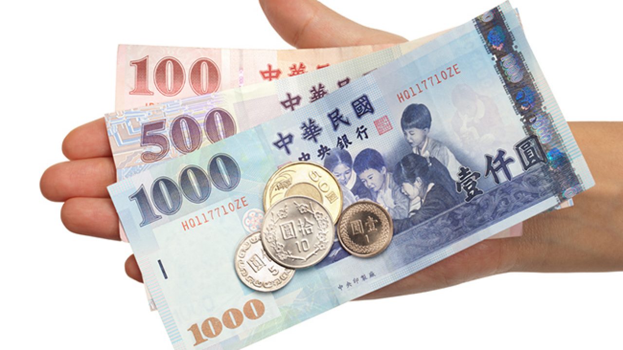 Tiền giấy Đài Loan với mệnh giá 100, 500, 1000 yuan và các đồng xu trên tay
