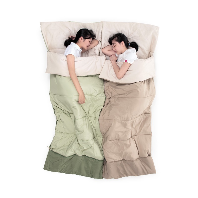 2 bạn nữ nằm trong 2 túi ngủ xanh và hồng cạnh nhau ngủ ngon lành