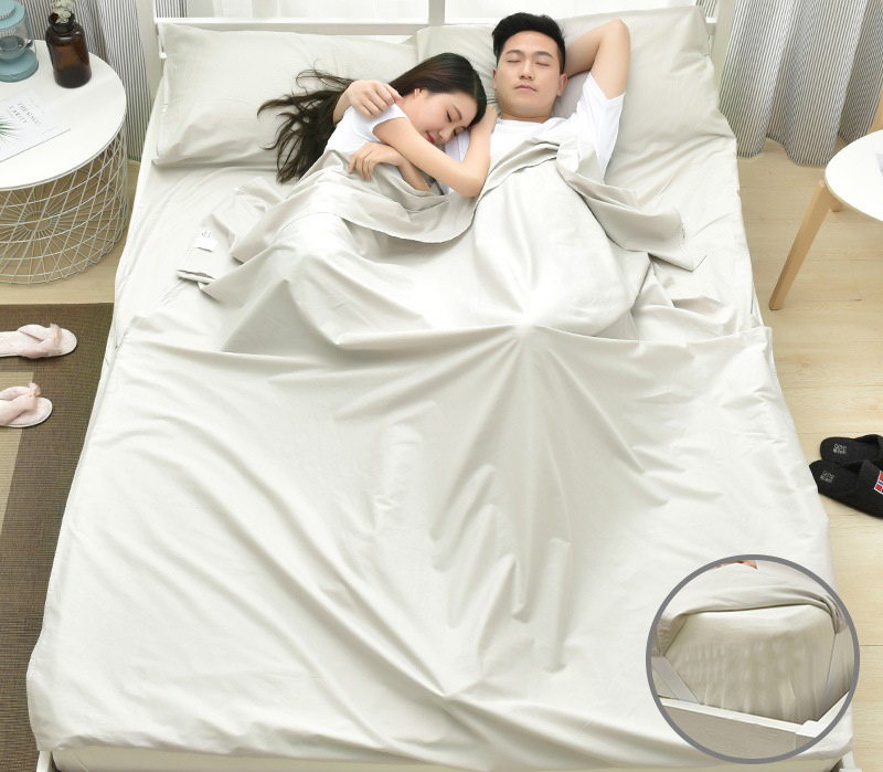 Đôi vợ chồng trẻ nằm ngủ cùng nhau trong túi ngủ màu trắng