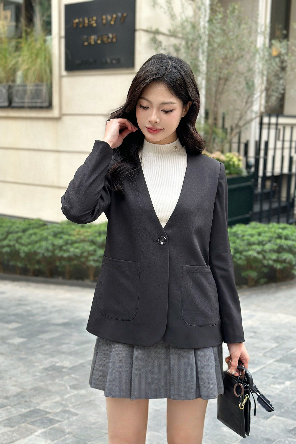 Phối áo vest đen với chân váy xếp ly