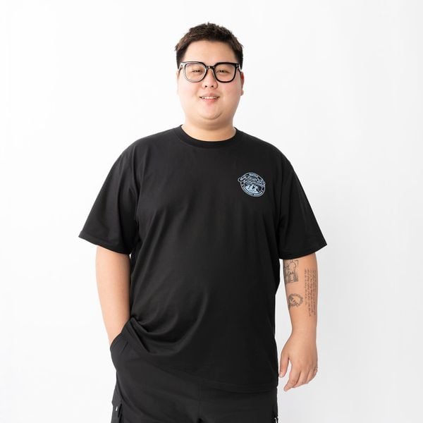 Người đàn ông béo mặc áo thun đen big size có logo xanh ở ngực trái