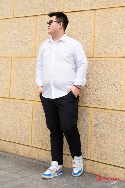 Người mẫu nam ngoại cỡ mặc áo sơ mi trắng kết hợp với quần âu đen và giày nike