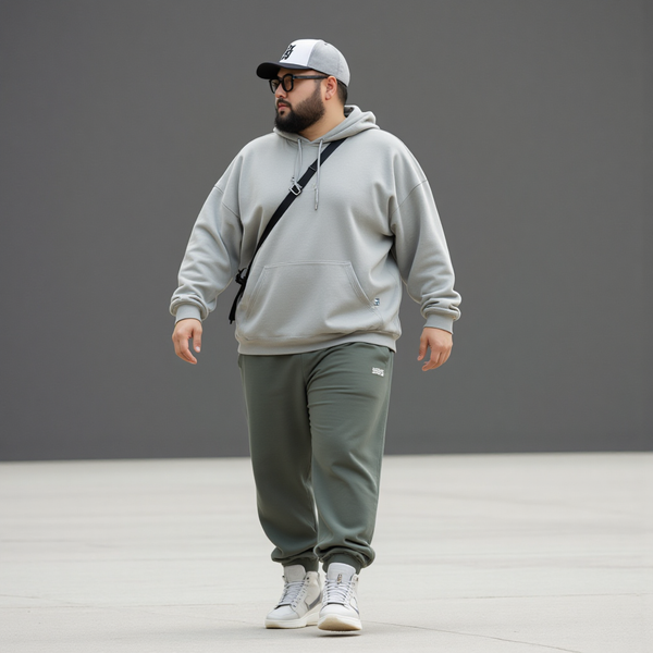 Một người mẫu nam ngoại cỡ tự tin sải bước trong trang phục thể thao: áo hoodie quá khổ màu trung tính