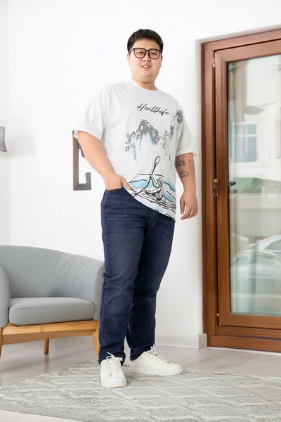 Người mẫu nam mặc set đồ big size: Áo thun trắng in họa tiết kết hợp với quần jean xanh và sneaker trắng