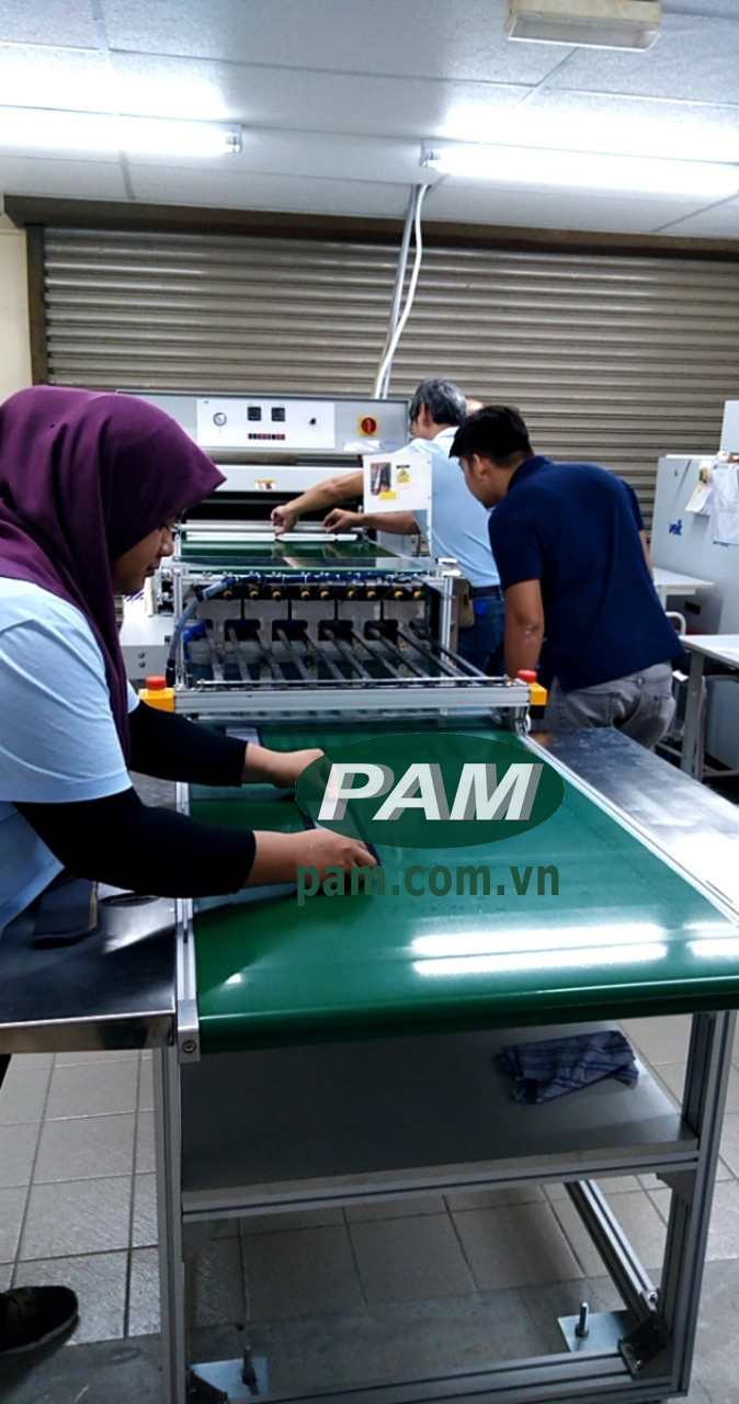 công nhân malaysia thao tác với băng tải pam