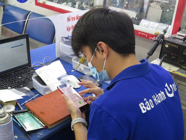 Kỹ thuật viên kiểm tra màn hìnhđiện thoại tại Bảo Hành One