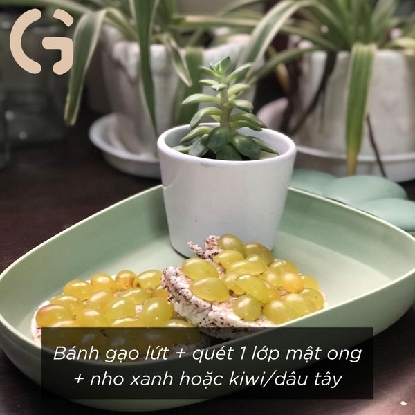 Bánh gạo lứt + quét 1 lớp mật ong + nho xanh hoặc kiwi/dâu tây