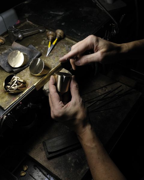 Đôi tay nghệ nhân tỉ mỉ khắc họa từng đường nét trên tay nắm kim loại, như thổi hồn vào chất liệu