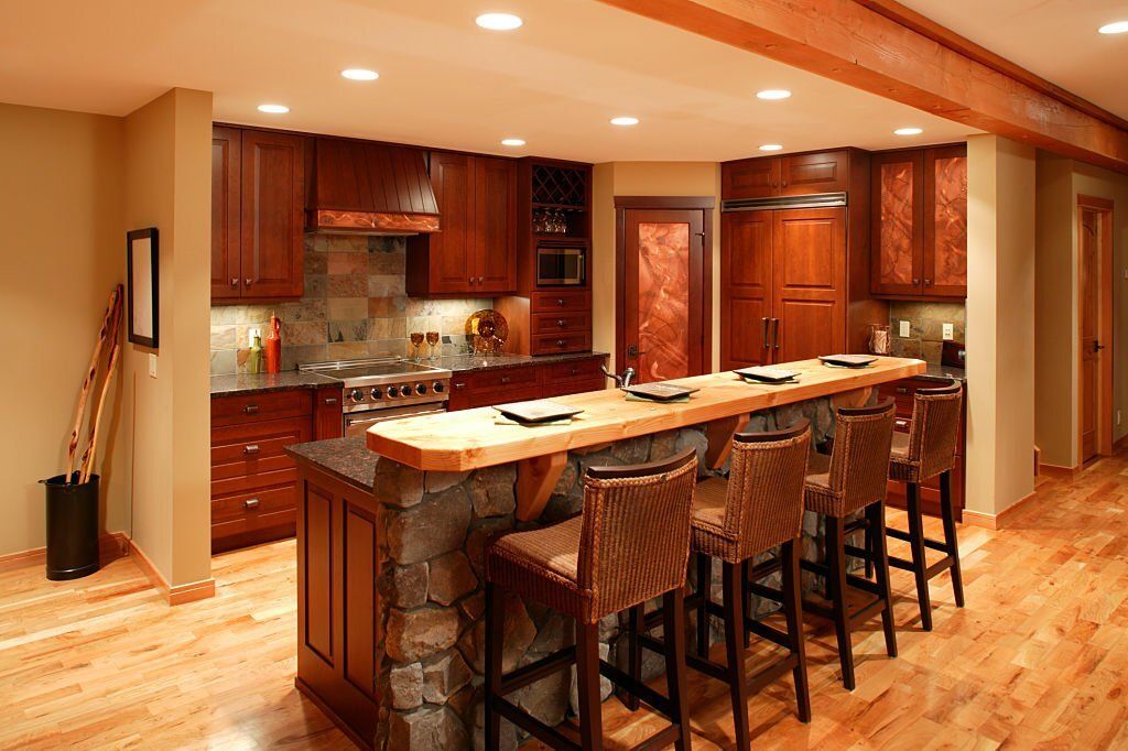 Tủ bếp gỗ cẩm lai kèm bàn đảo có quầy bar trong căn bếp sang trọng