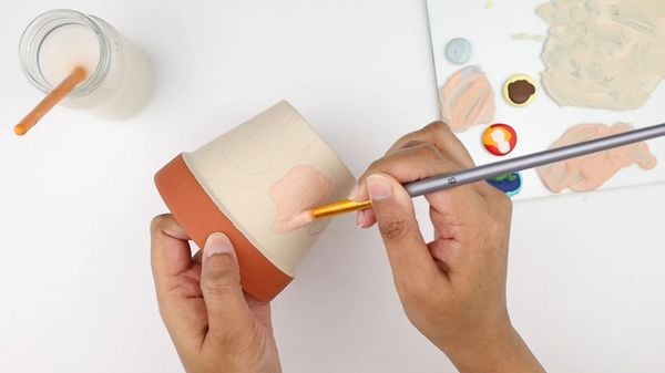 Hand-painting a clay pot