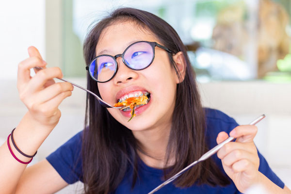 Ăn nhai sai cách cũng là một trong những nguyên nhân gây ra tình trạng niềng răng bị hóp má