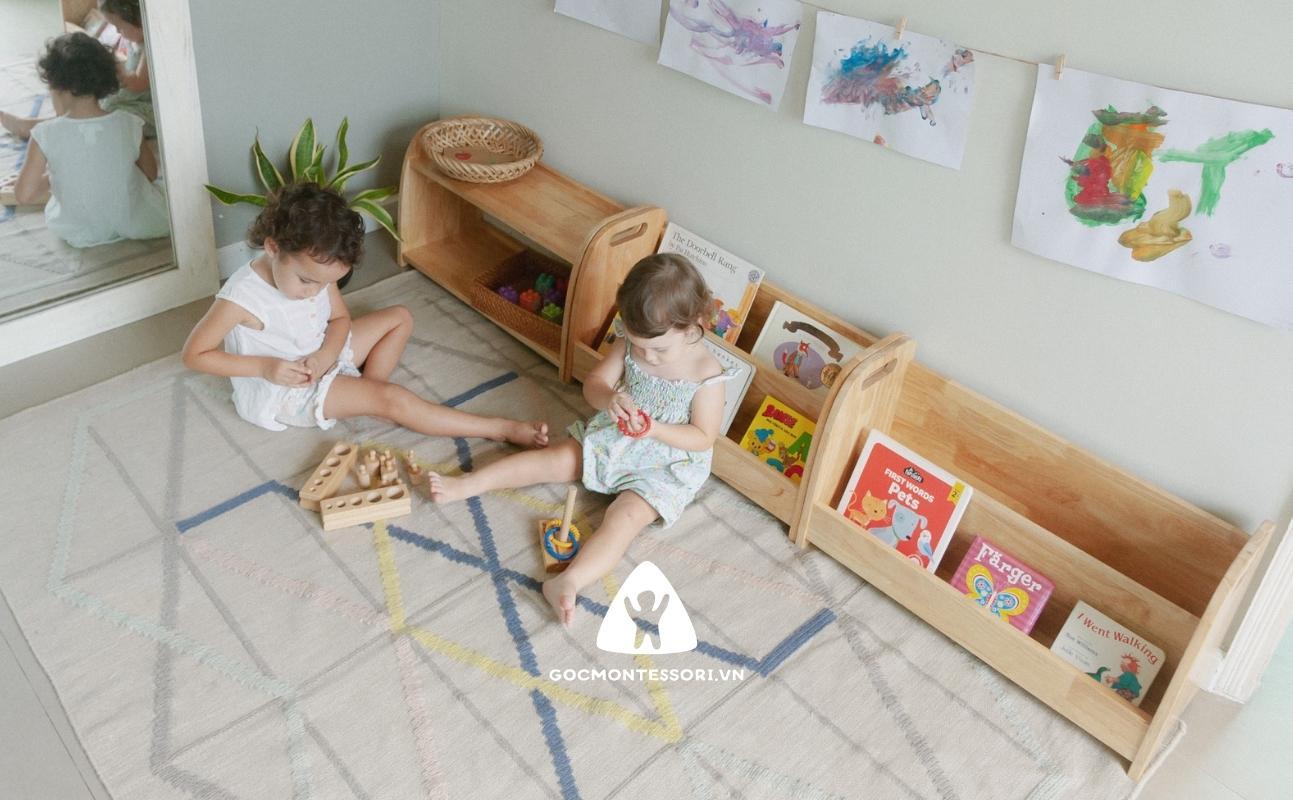 Các loại tủ kệ Montessori khác nhau được đặt dựa vào tường và trưng bày nhiều sách và đồ chơi khác nhau.