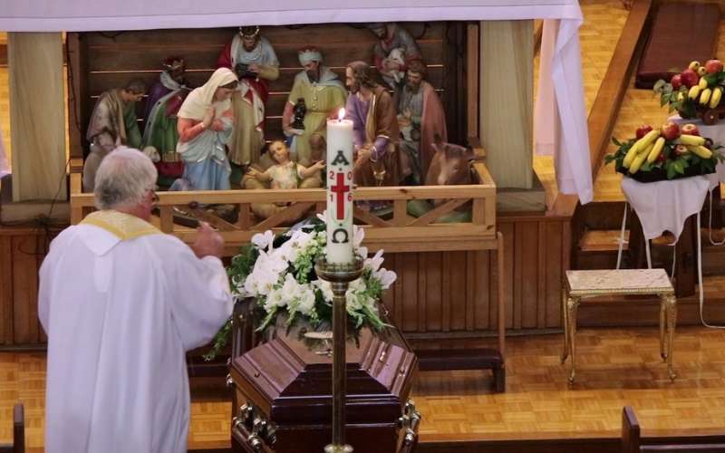 Thập giá, Chúa Giêsu, Đức mẹ, nến và hoa huệ trắng là những hình ảnh thường thấy trong đám tang công giáo
