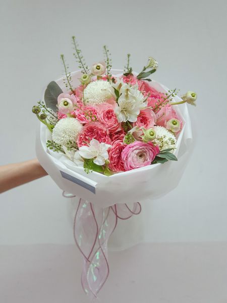 Bó hoa hồng dáng tròn xinh xắn được trang trí cẩn thận và khéo léo.