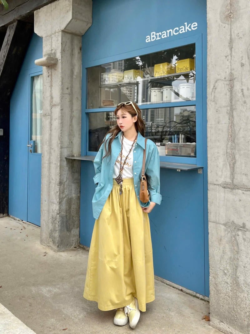 Chân váy màu vàng kết hợp với áo màu xanh ngọc