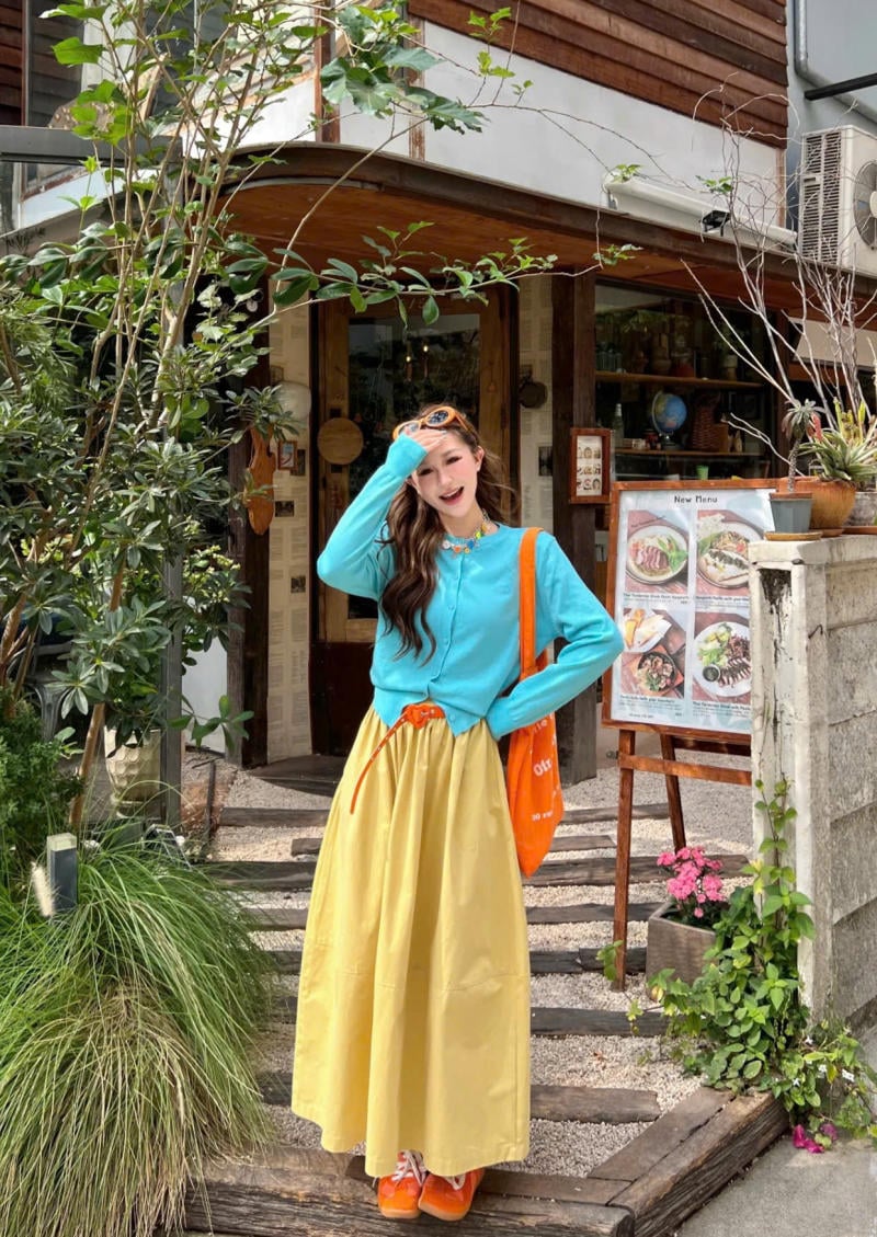 Chân váy màu vàng kết hợp với áo màu xanh ngọc