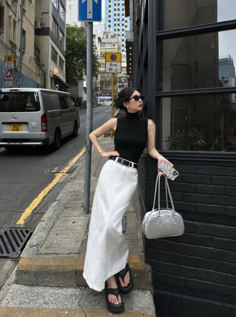 Áo ba lỗ cổ lọ đen + chân váy maxi trắng + dép đế cao