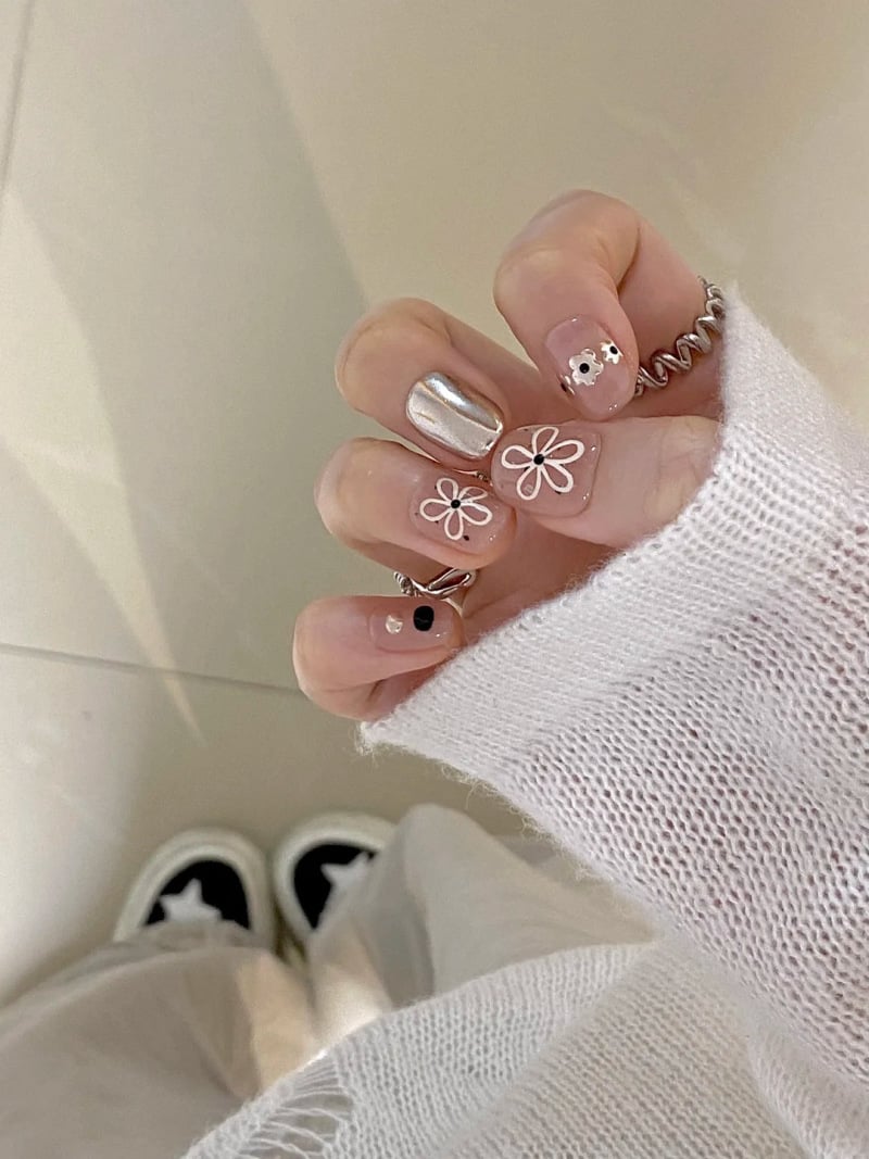 Kiểu móng tay tráng gương đẹp với họa tiết hoa trên nền ánh kim, mang lại vẻ sang trọng kết hợp cùng nét dịu dàng