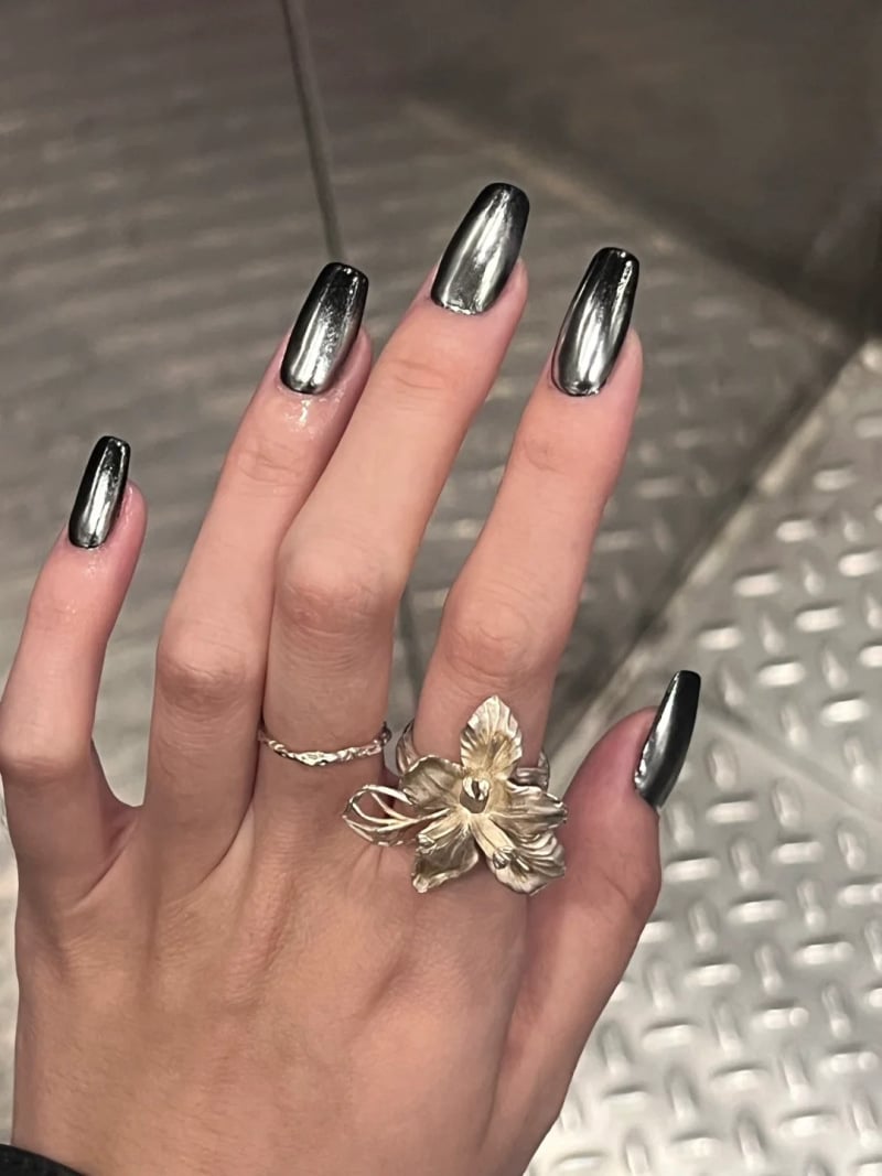 Móng tay tráng gương đẹp màu đen tuyền trên nền móng dài, thể hiện phong cách cá tính và đầy quyền lực