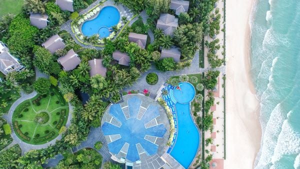 Resort bao quanh rừng cây bên bãi biển có hồ bơi nhìn từ trên cao