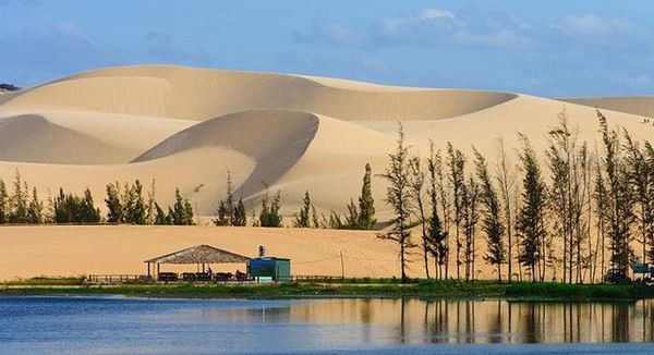 Đồi cát cao như núi ở Bàu Trắng bên cạnh hồ nước