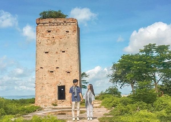 ngôi tháp đứng giữa bầu trời xanh mây trắng