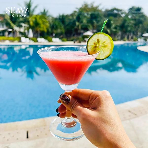 ly cocktail màu đỏ phía sau là hồ bơi