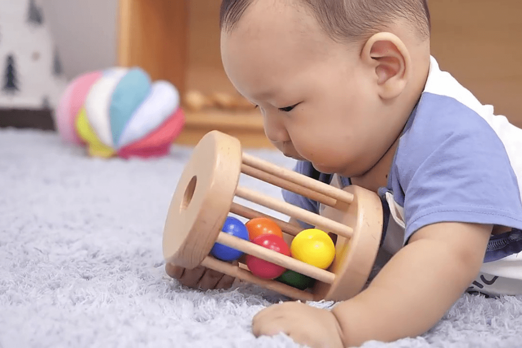 Hình ảnh trẻ chơi sản phẩm Chiếc trống lăn trong Hộp đồ chơi Xem Xét của Kinderlove cho bé 6-7 tháng tuổi