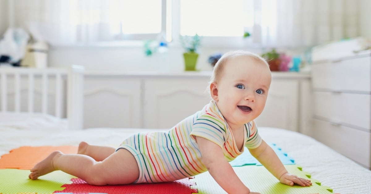 Trẻ nằm sấp và kéo người về phía trước bằng cách sử dụng tay