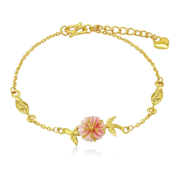 Lắc tay vàng 24K họa tiết hoa đào tinh xảo, kết hợp sắc hồng dịu dàng của đá xà cừ, tôn lên vẻ đẹp thanh tao và rạng rỡ của chủ nhân sở hữu