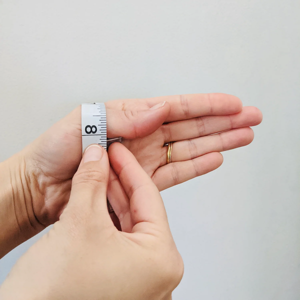 Dùng thước dây đo vòng quanh phần rộng nhất của bàn tay