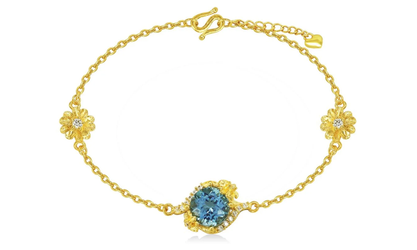 Lắc tay họa tiết hoa đính đá Topaz mang sắc xanh dịu nhẹ, thể hiện ý nghĩa may mắn, thịnh vượng và là biểu tượng của sự thanh tao
